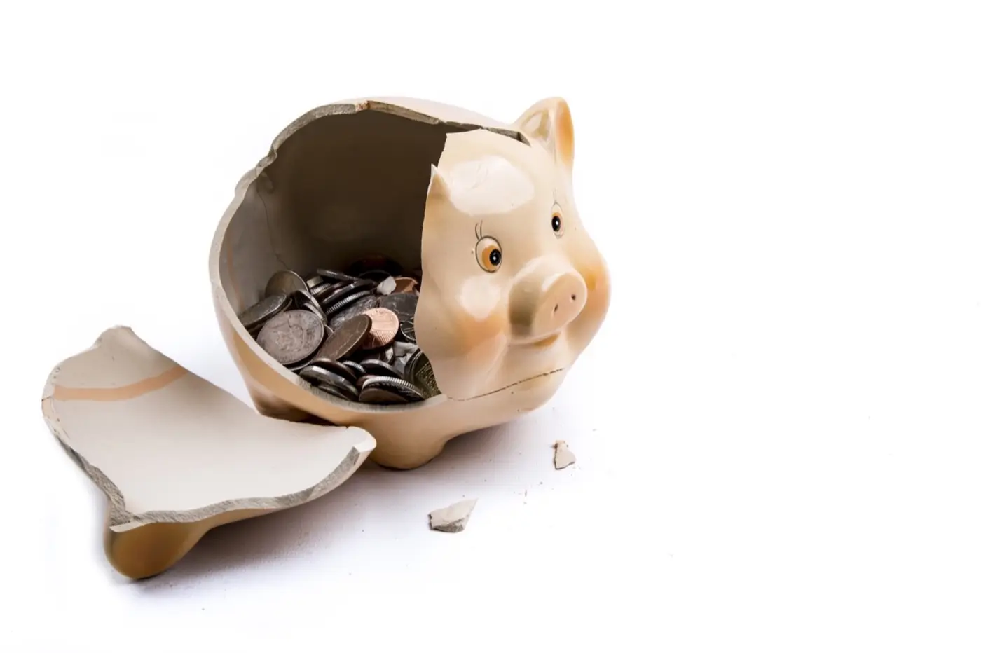 A broken piggy bank with some coins visible inside.