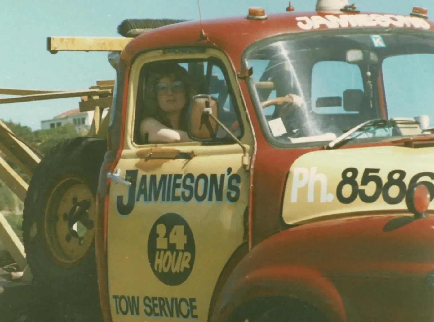 An old photograph of a tow truck with Jamieson's 24 Hour Tow Service written on the driver's door.